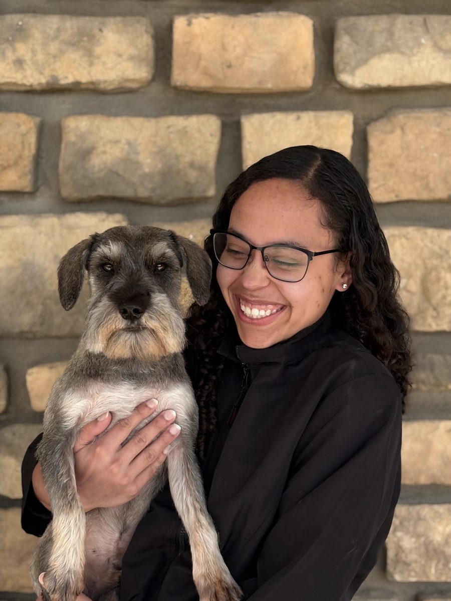 Victoria Love, groomer at Oasis Grooming Salon, holding a schnauzer